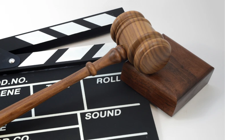 Gavel and clapperboard on white background.