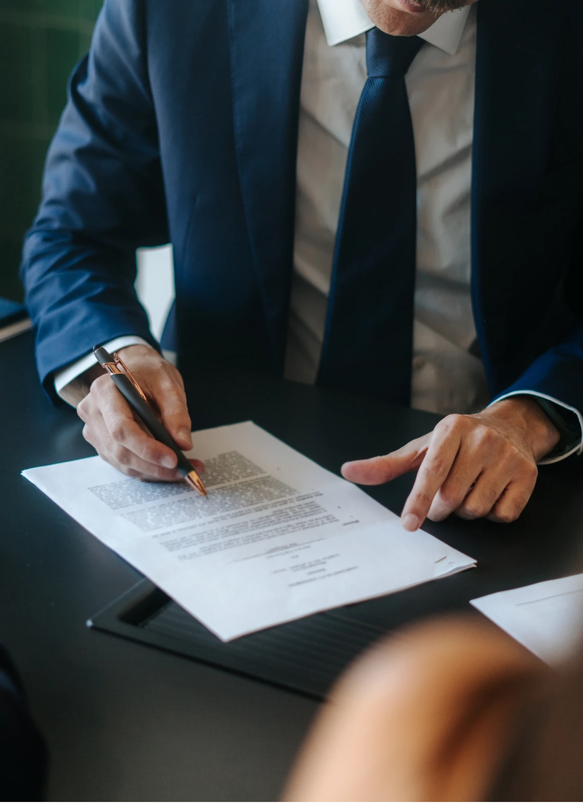 Man signing a document in office setting.